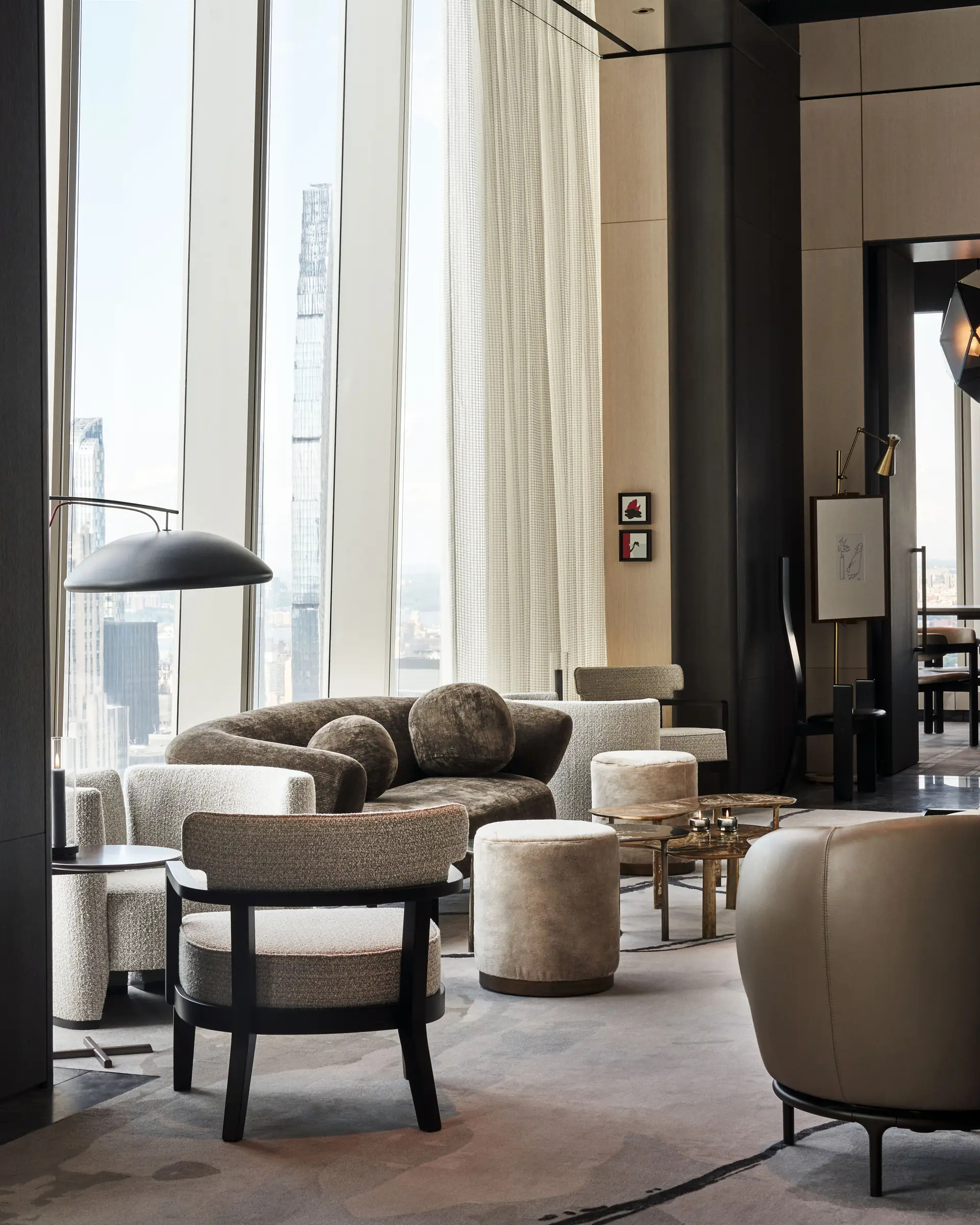 Lounge with olive velvet sofa, boucle armchairs and floor-to-ceiling windows over the Manhattan skyline, for Centurion New York.