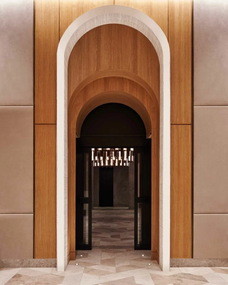 Arched wood-paneled entrance with marble floor and glowing chandelier beyond, for Brooklyn Tower.