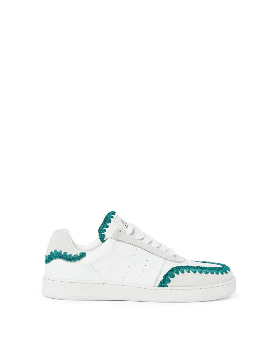 White leather low-top sneaker with suede panels and teal whipstitch trim on a white background, for Loeffler Randall.